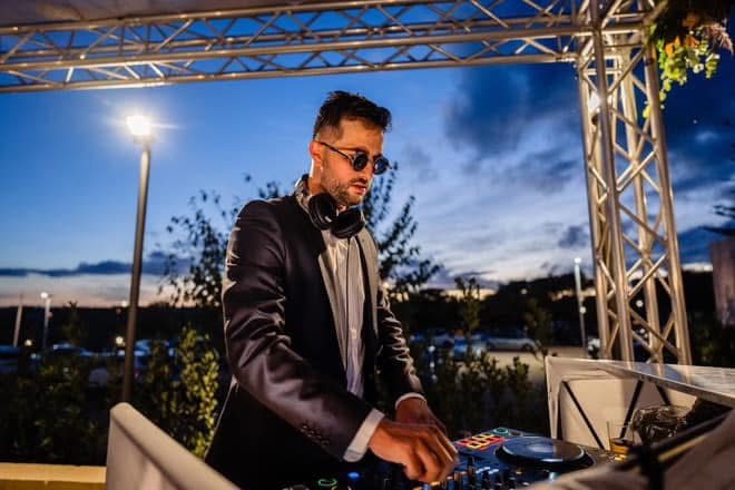DJ in black tie at a dusk drinks reception