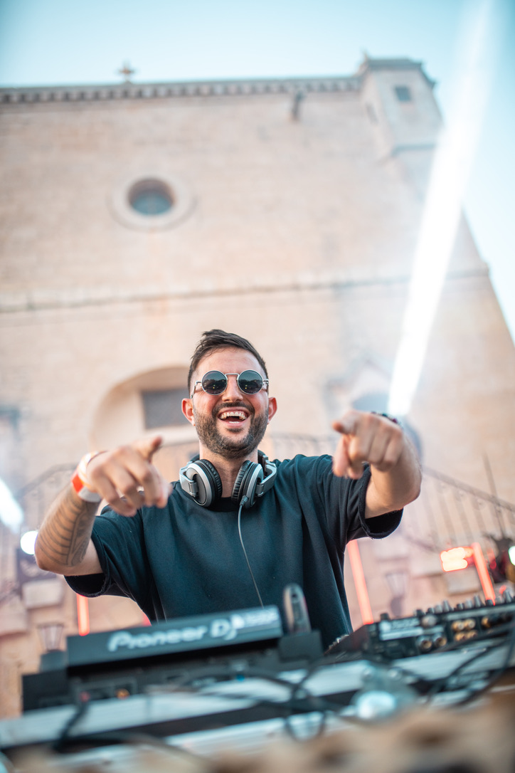 DJ pointing to the crowd at a daytime fort party