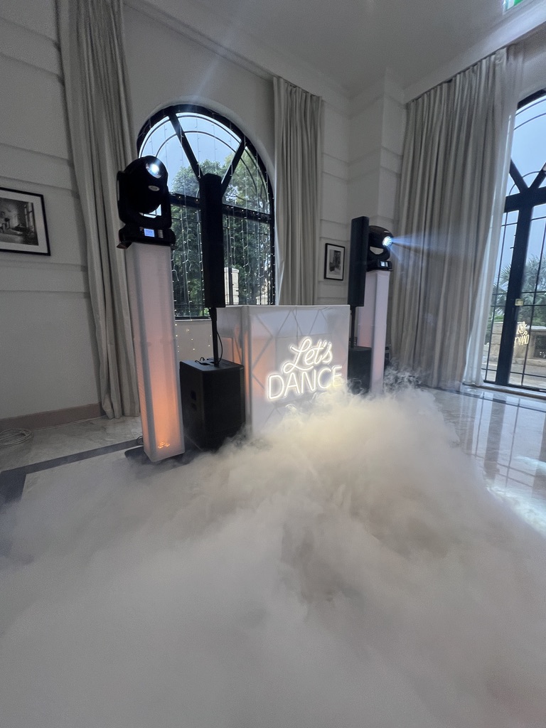 Low fog rolling across a marble floor in front of the DJ booth