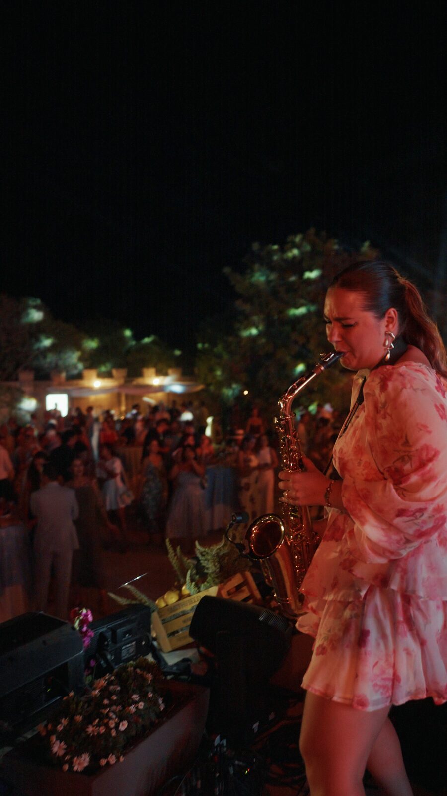 Saxophone over the crowd at an outdoor reception