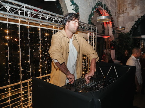 DJ playing beside a fairy light curtain at a Christmas party