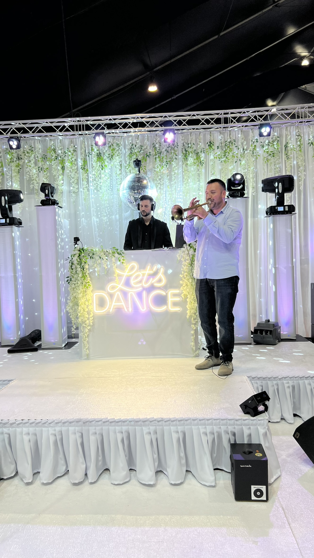 Live trumpet alongside the DJ on a white stage