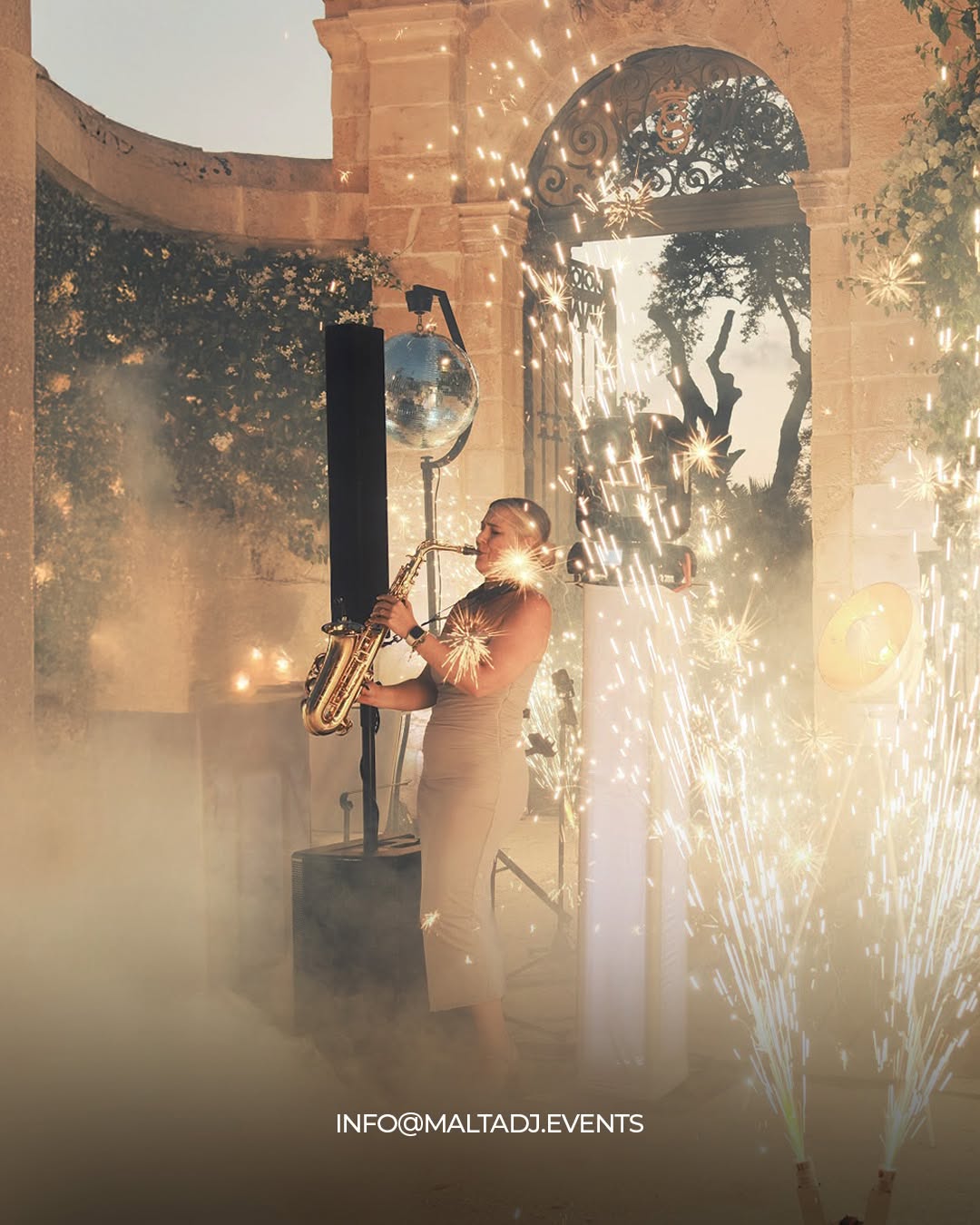 Saxophonist playing amid cold sparks and low fog under a stone rotunda