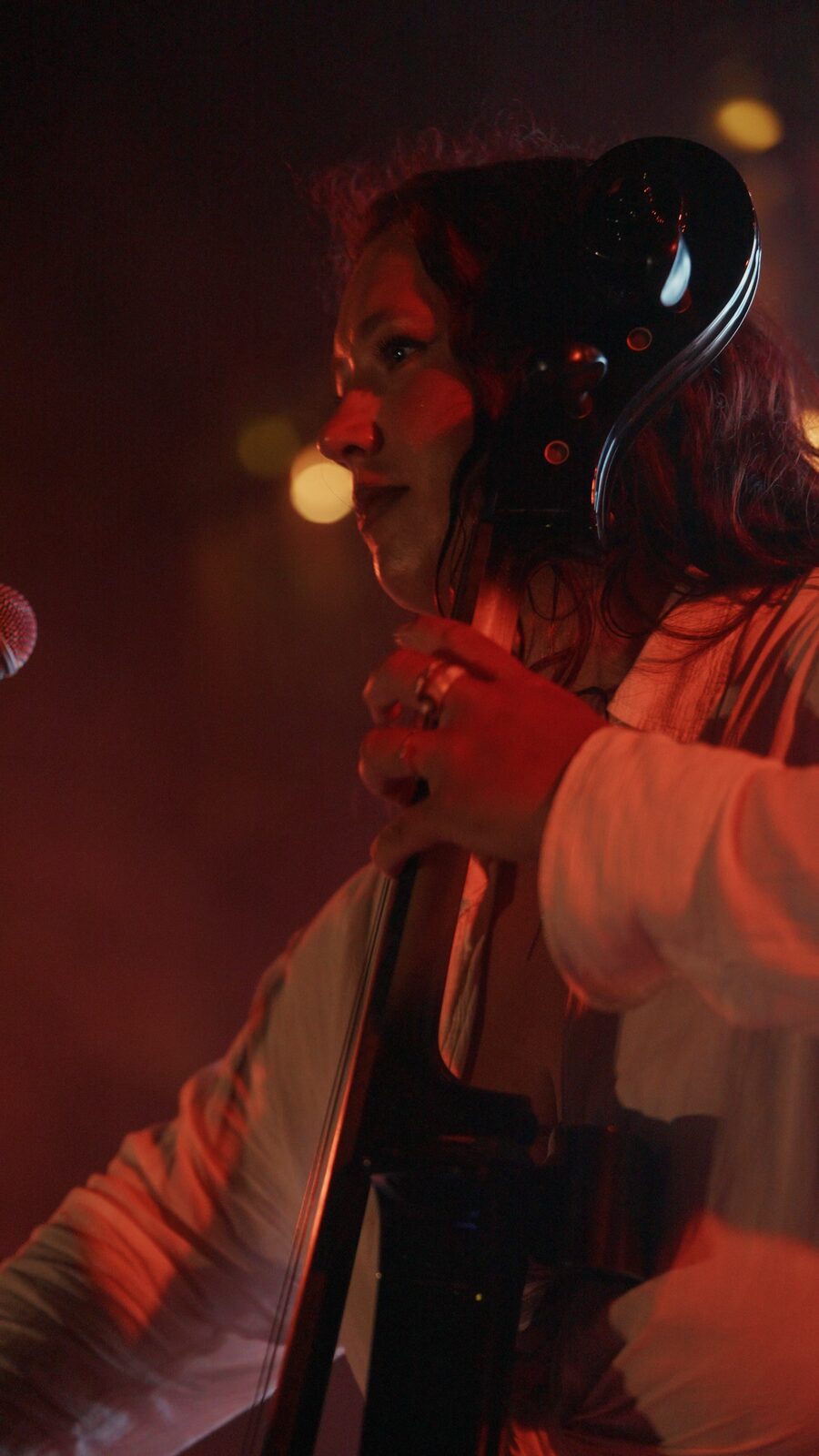 Cellist performing in warm red light