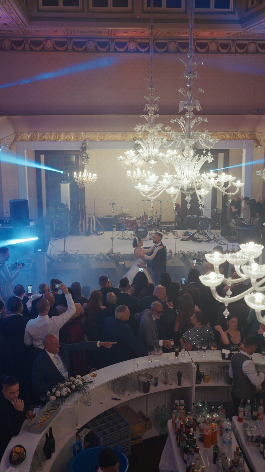 Cold spark fountains framing the first dance beneath the chandeliers