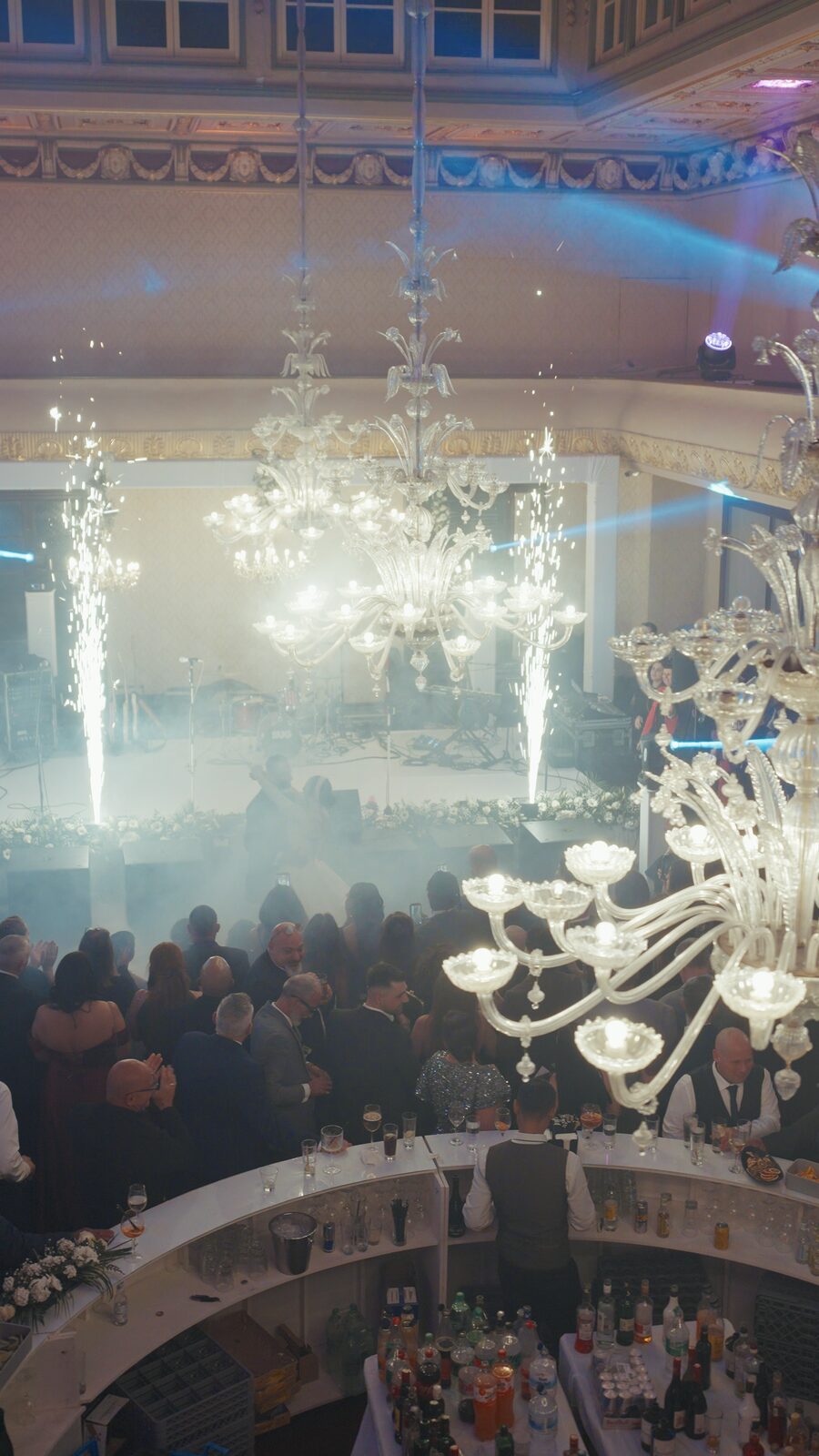 Spark fountains rising either side of the stage as guests applaud
