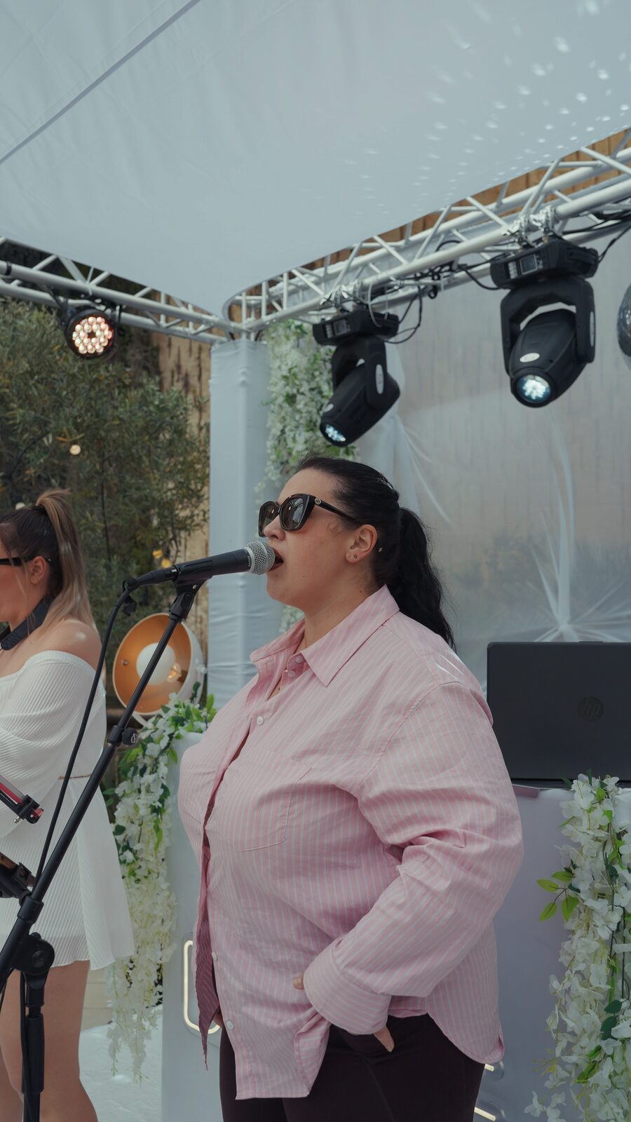 Vocalist and saxophonist performing under the truss canopy