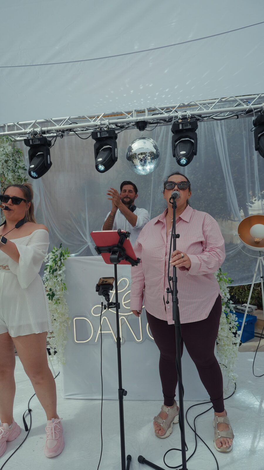 Singer and saxophonist beside the Lets Dance sign with the DJ behind