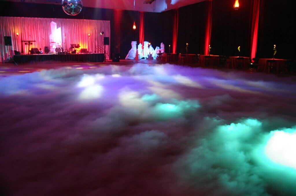 Low fog machines in corporate events create a dramatic ambiance by producing a ground-hugging fog. They enhance visual effects, highlight special moments, and set the mood, adding sophistication and mystique. By enveloping entrances and stages, they make presentations and product launches visually striking, leaving a lasting impression on attendees. These machines are essential for themed events, boosting brand image and creating memorable, immersive experiences while being safe and environmentally friendly.